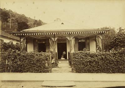 Casa com senhora e cachorro sentados à frente