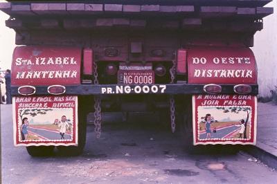 Para-choque de caminhão com a frase: "Amar é fácil, mas ser sincera é difícil // A mulher é uma joia falsa"