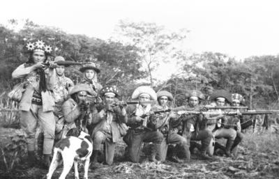 Corisco e Dadá com bando de cangaceiros em posição de tiro