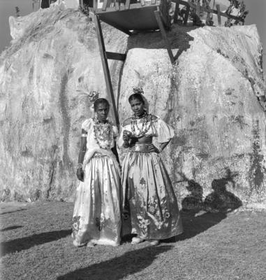 Mulheres fantasiadas em frente a uma decoração de rua no carnaval carioca