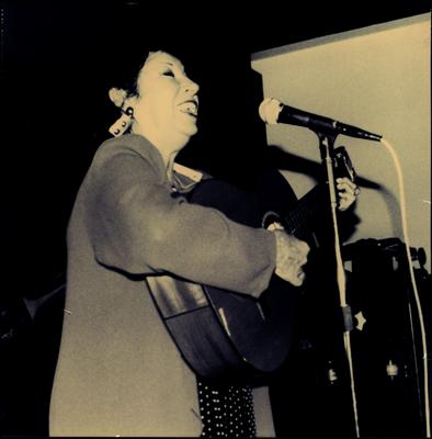 Inezita Barroso ao microfone com o violão