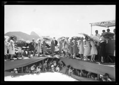 Concurso mundial de beleza; misses desfilam, sob a passarela, crianças espiam