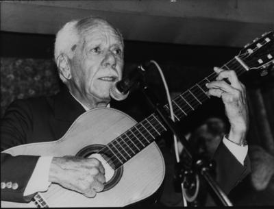 Silvio Caldas ao microfone com o violão