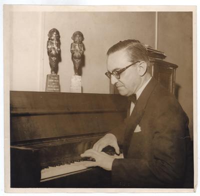 Gabriel Migliori ao piano com troféus
