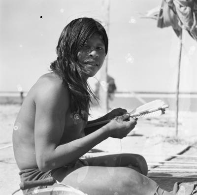 Homem do povo Karajá confeccionando flechas