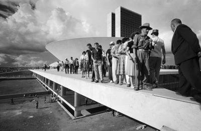 Populares sobre cobertura do palácio do Congresso Nacional no dia da inauguração de Brasília