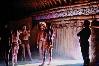 Série Xingu - Homens no interior de maloca com tora decorada