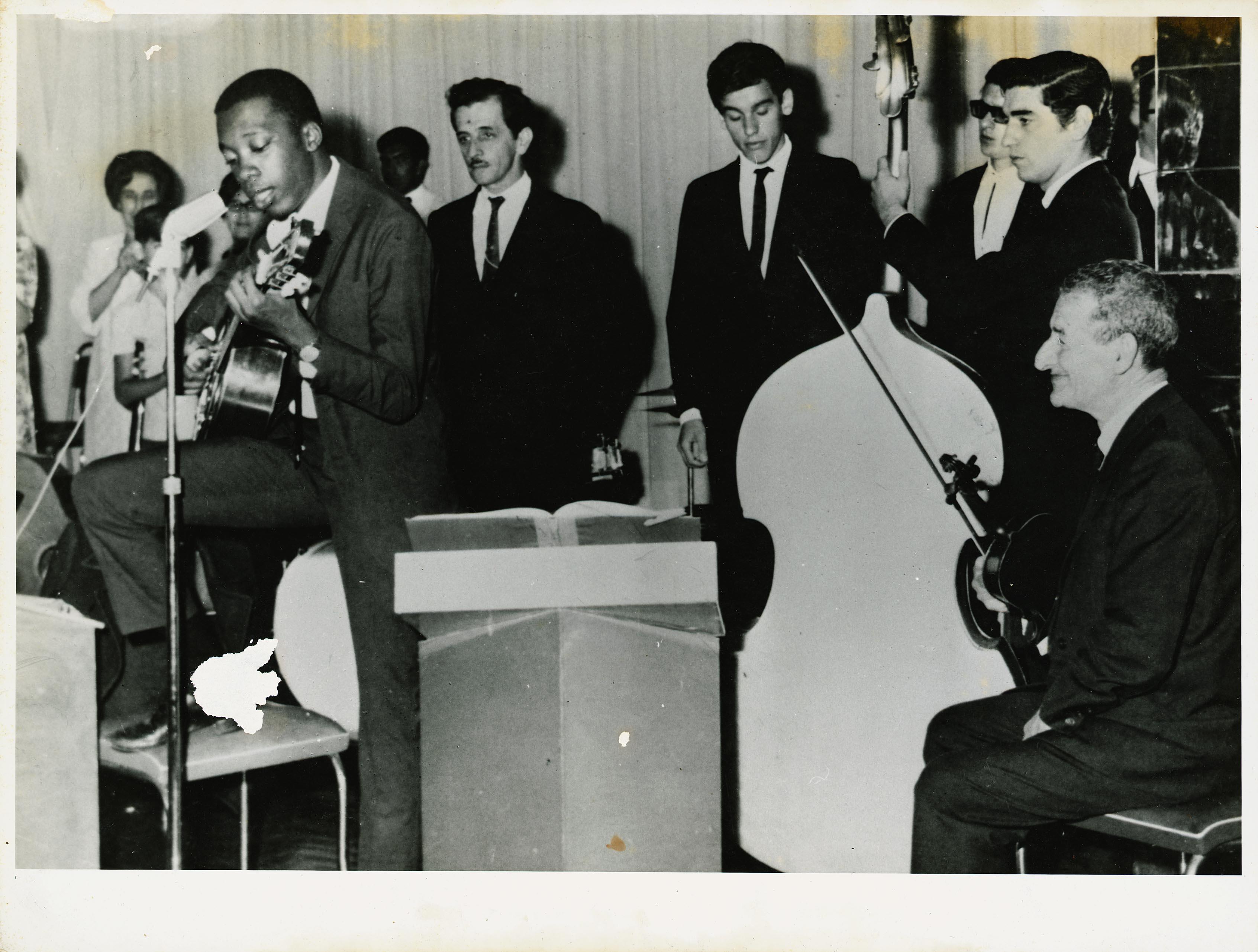 Milton Nascimento ao microfone com o violão