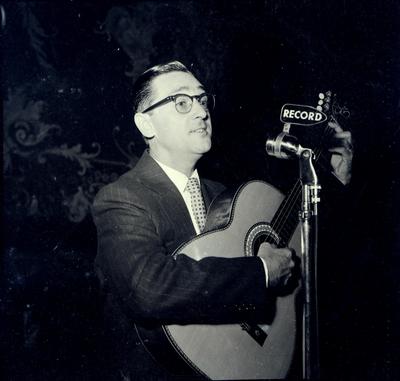 Paulo Tapajós ao microfone com o violão