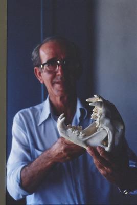 Homem não identificado com crânio de animal nas mãos