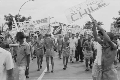 Calouros com roupa de estopa desfilam pela avenida W3 segurando cartazes como parte do trote da Universidade de Brasília