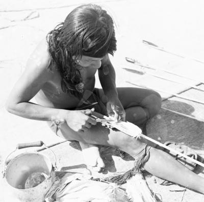 Homem do povo Karajá confeccionando flechas