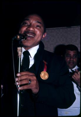 Lupicínio Rodrigues ao microfone com medalha