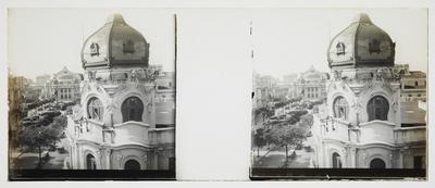 Cúpula de edifício e, ao fundo, o Teatro Municipal; tomados da Rua de Santa Luzia, esquina com a Avenida Central (atual Rio Branco)