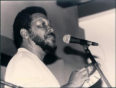 Martinho da Vila ao microfone com tamborim