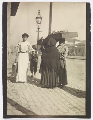 Grupo de vendedoras de verduras e transeuntes