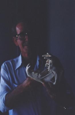 Homem não identificado com crânio de animal nas mãos