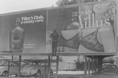 Homem trocando outdoor