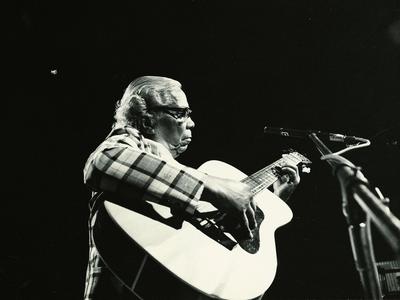 Nelson Cavaquinho ao microfone com o violão